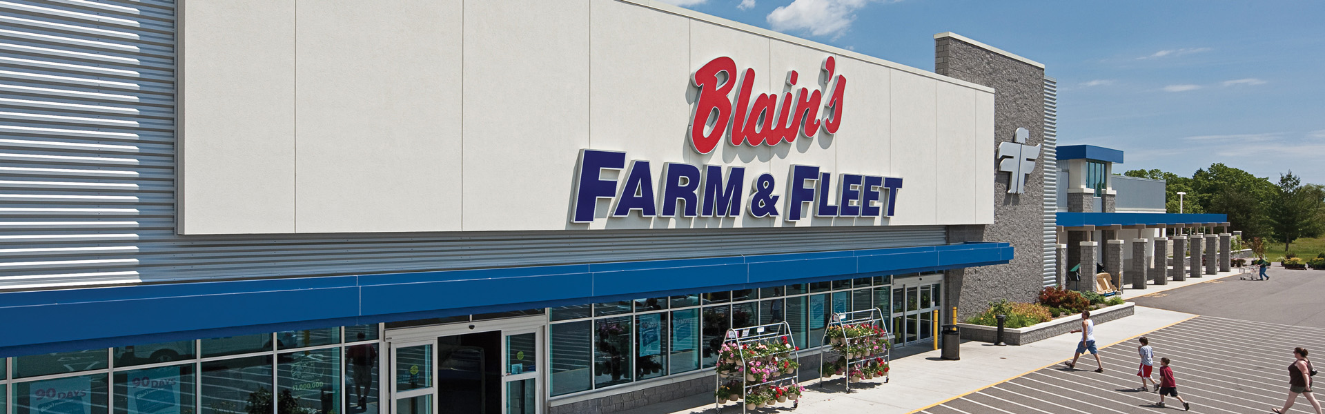 Blain's Farm & Fleet storefront with metal panel cladding and blue awning trim